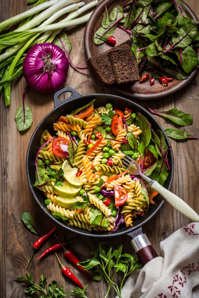Bunter Nudelsalat mit Paprika, Limetten, Spinat, Chili, Zwiebeln und Rotkohl.